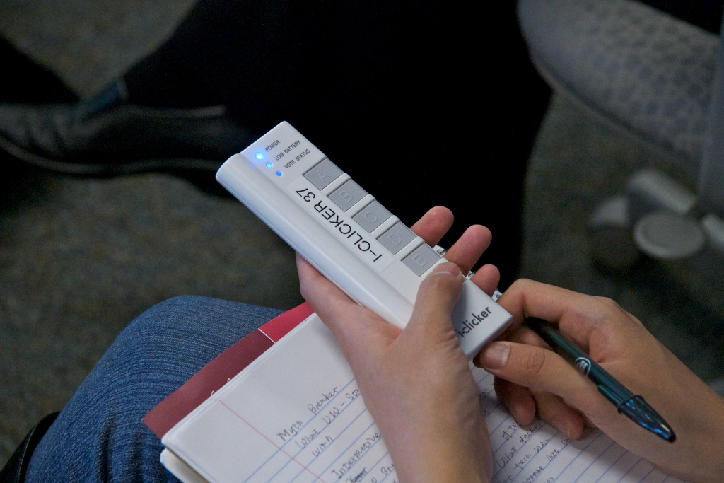 A participant using a clicker to respond to a speakers question
