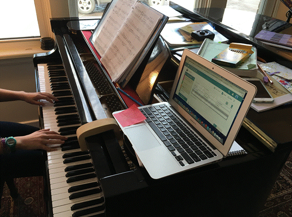 A laptop on top of a piano